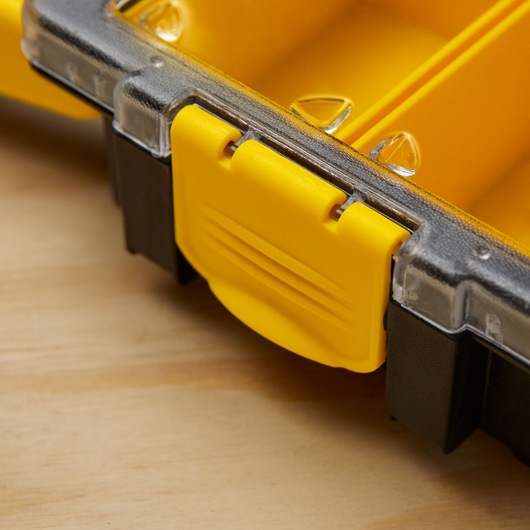 STANLEY 014725R photography of yellow plastic latch on black and clear organizer box, close-up angle.