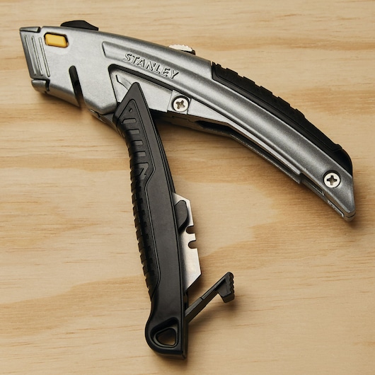 Photo of STANLEY 10-788 utility knife, silver and black with ergonomic handle, shown on wooden surface.