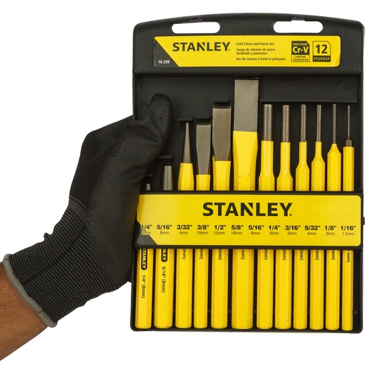 Photo of STANLEY 16-299 chisel and punch set, 12-piece, yellow tools in black case held by gloved hand, front view.