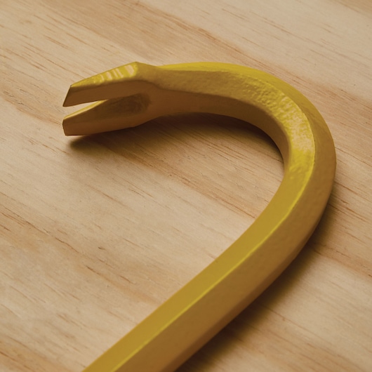 STANLEY 55-118 yellow pry bar close-up on wood surface, showing curved end with split claw.