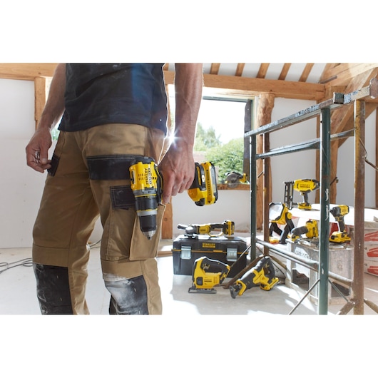 STANLEY SCG400M2K-KR power tools on jobsite, worker holding cordless drill, multiple yellow tools visible.