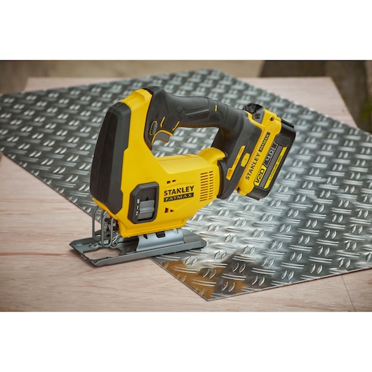 STANLEY SCJ600B jigsaw tool side view on metal sheet and wood surface, yellow and black design.