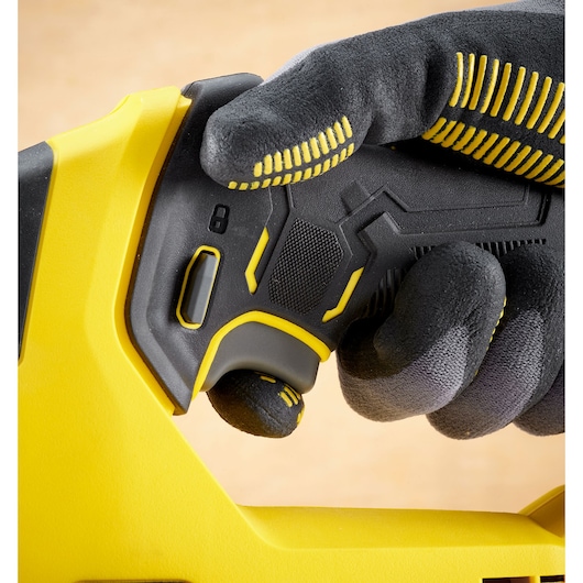 Close-up photo of STANLEY SCJ600B tool handle with textured grip and safety switch, worker wearing gloves.