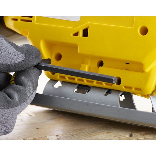 STANLEY SCJ600B jigsaw base close-up with gloved hand adjusting with hex key