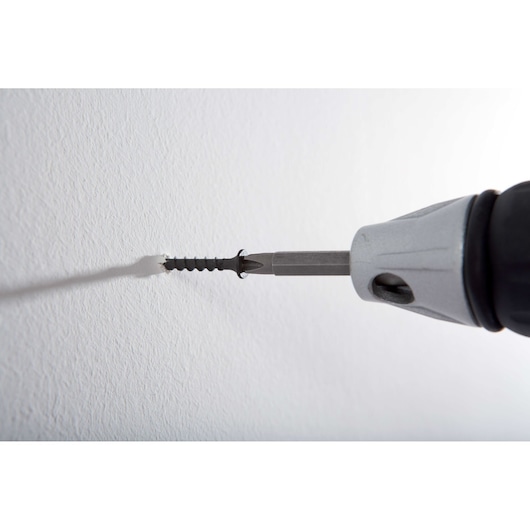 STANLEY STDR5206 drill driving a screw into a white wall, close-up side angle.