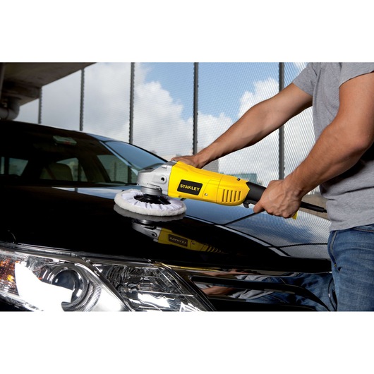 STANLEY STGP1318K polisher being used on black car hood, yellow body, car detailing context.
