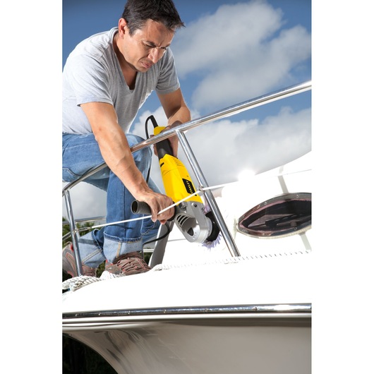 STANLEY STGP1318K yellow grinder used on boat railing, outdoor scene, photography product.
