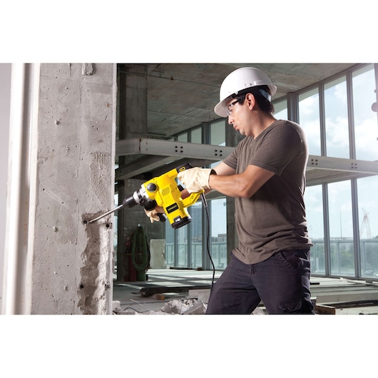 STANLEY STHR1232K rotary hammer being used to drill into a concrete wall at a construction site.