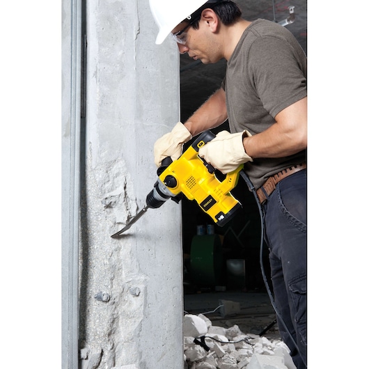 STANLEY STHR1232K rotary hammer drill in use on concrete, construction setting, side angle.