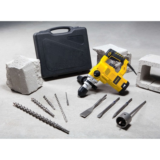 STANLEY STHR1232K rotary hammer drill with black carrying case and multiple drill bits, displayed on concrete surface.