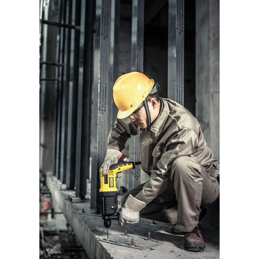 STANLEY STHR202K rotary hammer drill used on concrete by worker in safety gear at construction site.