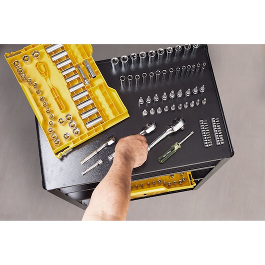 STANLEY STMT17993-LA socket and ratchet set with yellow case on workbench, hand selecting tool.