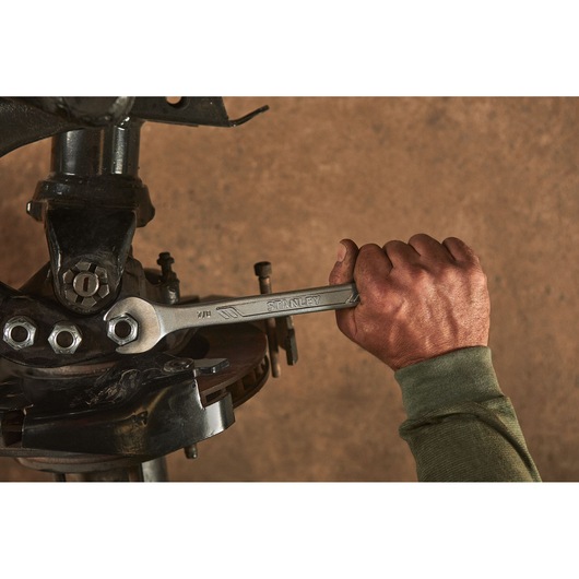 Photo of a hand using a STANLEY STMT72839 wrench on a car suspension bolt.