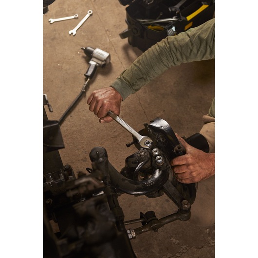 STANLEY STMT72839 wrench used on automotive part, photo shows hand gripping tool in workshop setting.