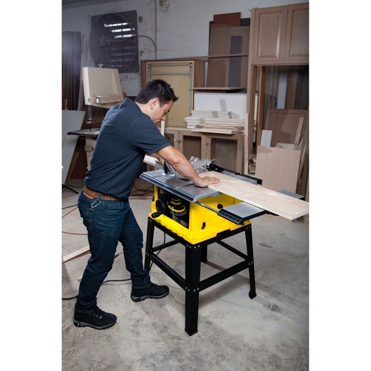 STANLEY STST1825 table saw in use, cutting a wooden board in a workshop environment.